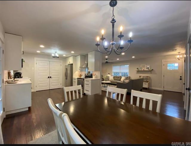 dining space with ceiling fan with notable chandelier and dark wood-type flooring