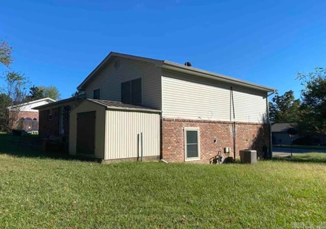 view of side of home featuring a yard, a storage unit, and central AC unit