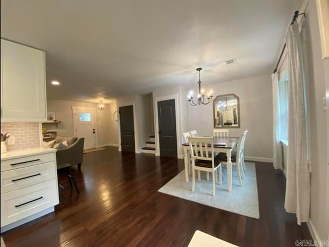 dining area featuring a notable chandelier and dark wood-type flooring