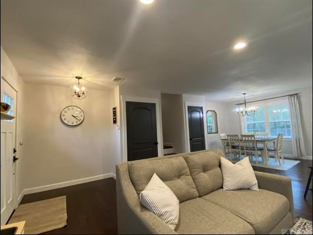 living room featuring an inviting chandelier and dark hardwood / wood-style floors