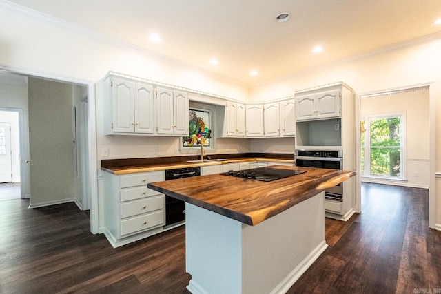 kitchen with black appliances, ornamental molding, wooden counters, and dark wood finished floors