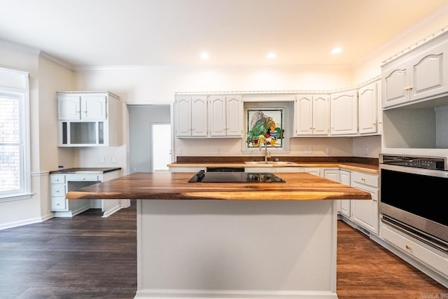 kitchen with dark wood finished floors, a sink, stainless steel oven, and a center island