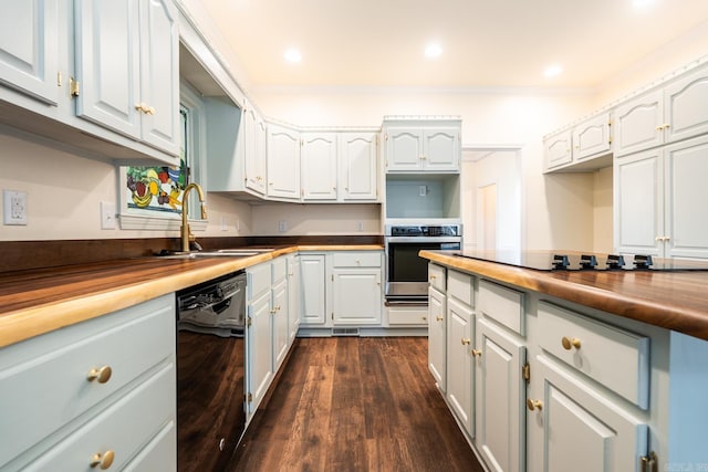 kitchen featuring black appliances, ornamental molding, a sink, and dark wood finished floors