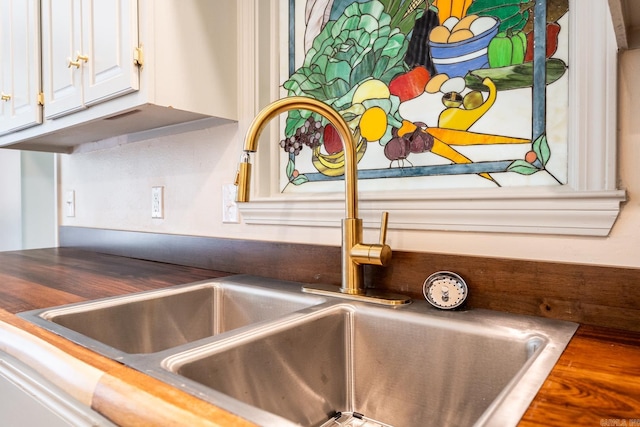 interior details featuring a sink and white cabinetry