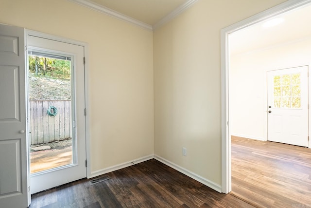 doorway with dark wood-style floors, visible vents, crown molding, and baseboards