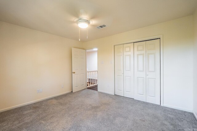 unfurnished bedroom with a closet, baseboards, visible vents, and carpet flooring