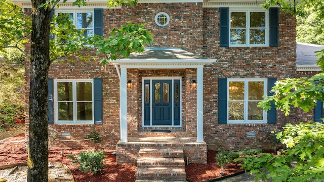 entrance to property featuring brick siding