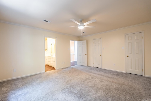 unfurnished bedroom featuring crown molding, light colored carpet, visible vents, connected bathroom, and baseboards