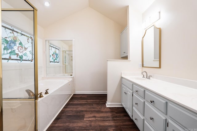 full bath featuring a garden tub, wood finished floors, vanity, vaulted ceiling, and a shower with door