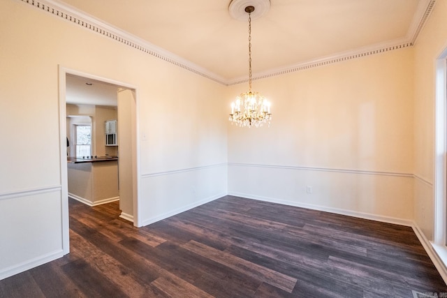 spare room with dark wood-style floors, crown molding, baseboards, and an inviting chandelier