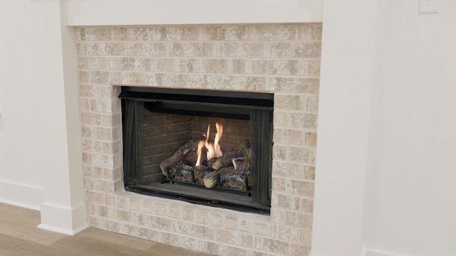 room details with wood-type flooring and a brick fireplace