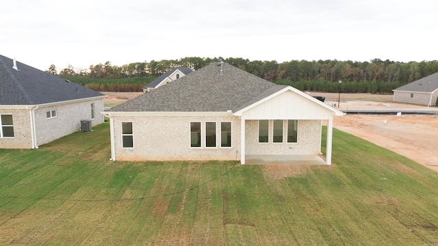 rear view of house featuring a lawn, central AC, and a patio area