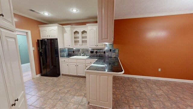 kitchen featuring backsplash, white cabinetry, black fridge with ice dispenser, and sink