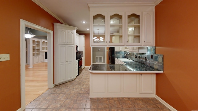 interior space featuring tasteful backsplash, sink, white cabinetry, kitchen peninsula, and ornamental molding