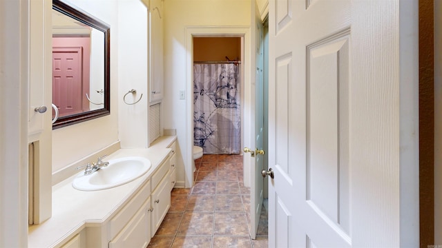 bathroom with a shower with curtain, vanity, tile patterned flooring, and toilet