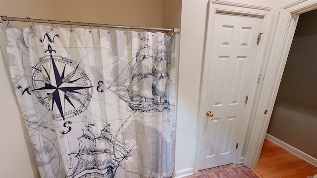 bathroom with hardwood / wood-style flooring and curtained shower