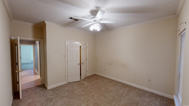 unfurnished bedroom with crown molding, light carpet, and ceiling fan