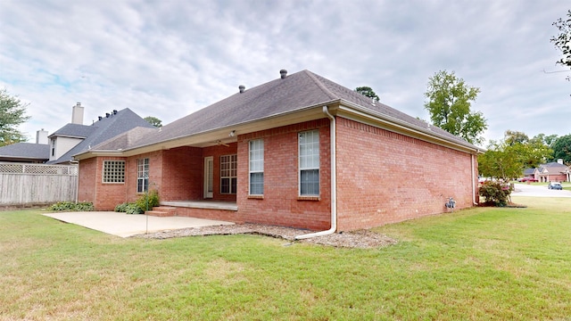 back of house with a lawn and a patio area