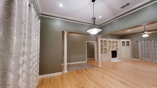 interior space with ceiling fan, ornamental molding, light hardwood / wood-style flooring, and decorative columns