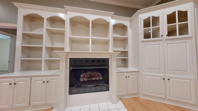 unfurnished living room with light hardwood / wood-style floors, a fireplace, and ornamental molding