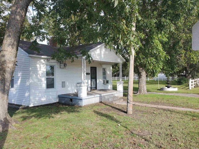 bungalow-style house featuring cooling unit and a front yard