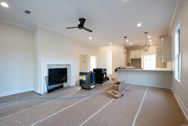 unfurnished living room featuring a fireplace, ceiling fan, and ornamental molding