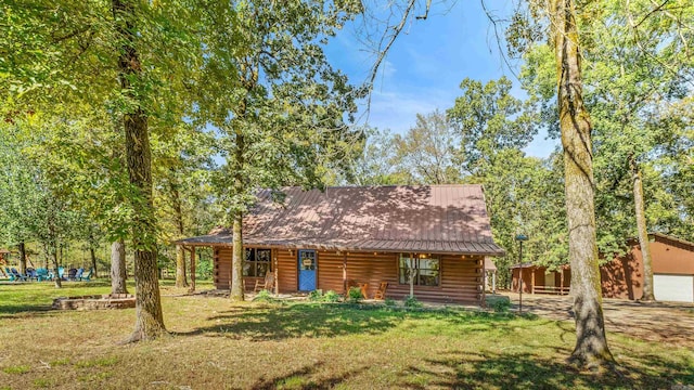 cabin featuring a garage, a porch, and a front lawn