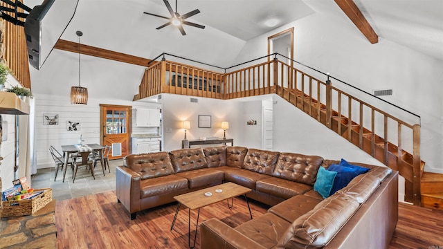 living room with ceiling fan, beam ceiling, wooden walls, high vaulted ceiling, and hardwood / wood-style floors