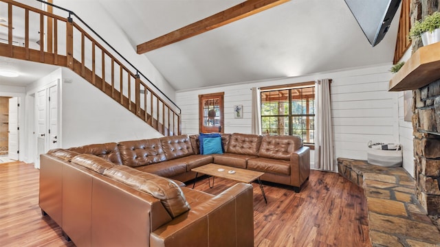 living room with wooden walls, beam ceiling, hardwood / wood-style floors, and high vaulted ceiling