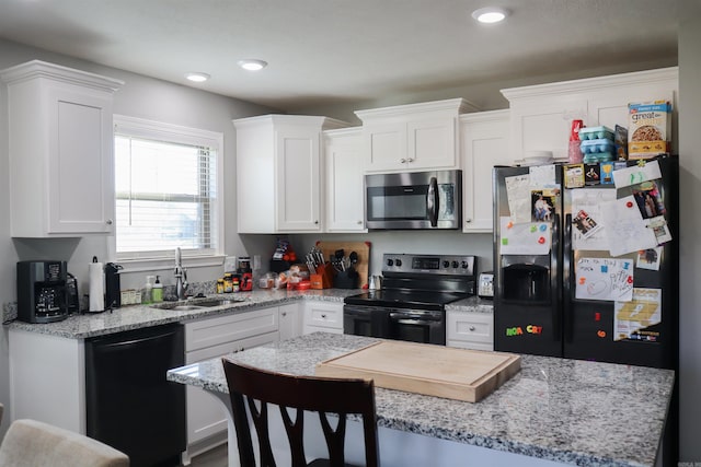 kitchen with appliances with stainless steel finishes, a breakfast bar, sink, and white cabinets