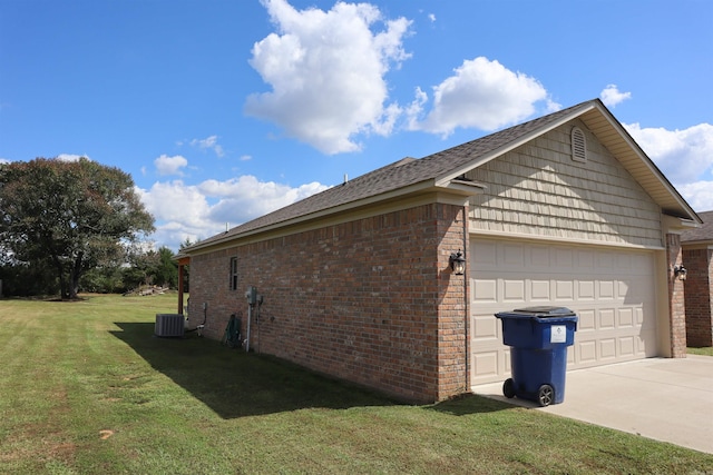 view of side of home featuring a garage, a lawn, and central air condition unit