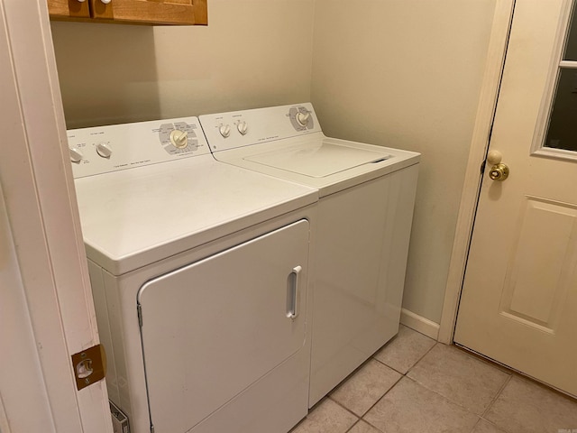 laundry room with washer and dryer and light tile patterned floors