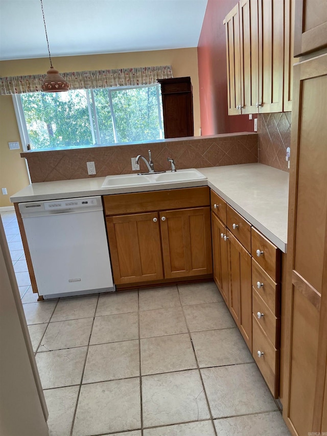 kitchen with white dishwasher, decorative light fixtures, sink, and a wealth of natural light