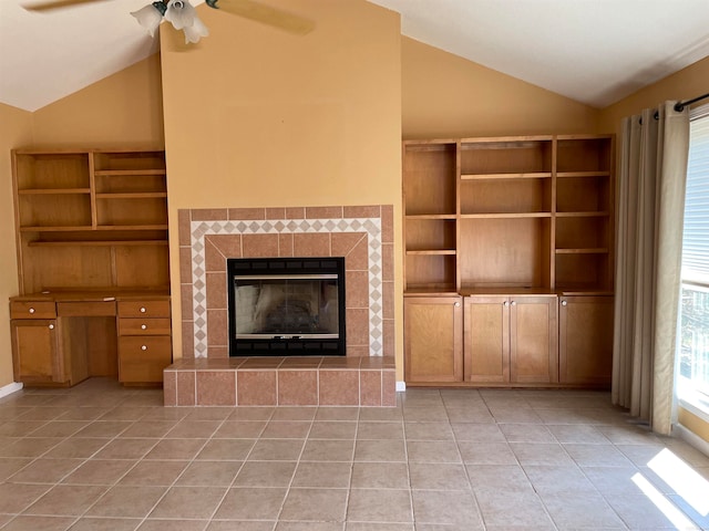 unfurnished living room with a tile fireplace, light tile patterned floors, high vaulted ceiling, and ceiling fan