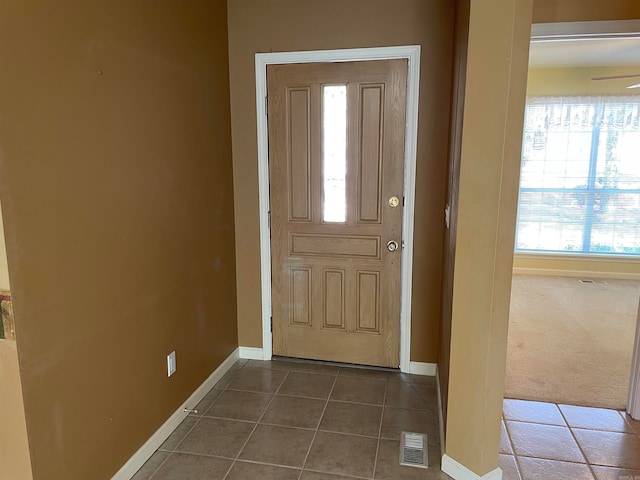 carpeted foyer entrance with ceiling fan