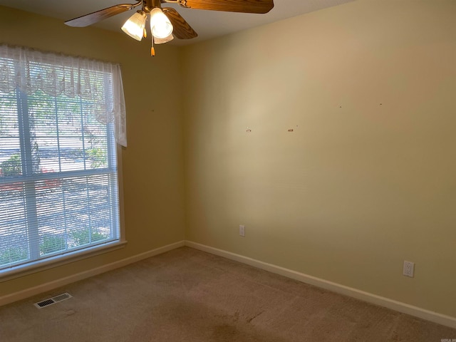 empty room with carpet flooring, ceiling fan, and plenty of natural light