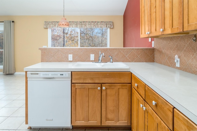 kitchen with white dishwasher, sink, a wealth of natural light, and tasteful backsplash