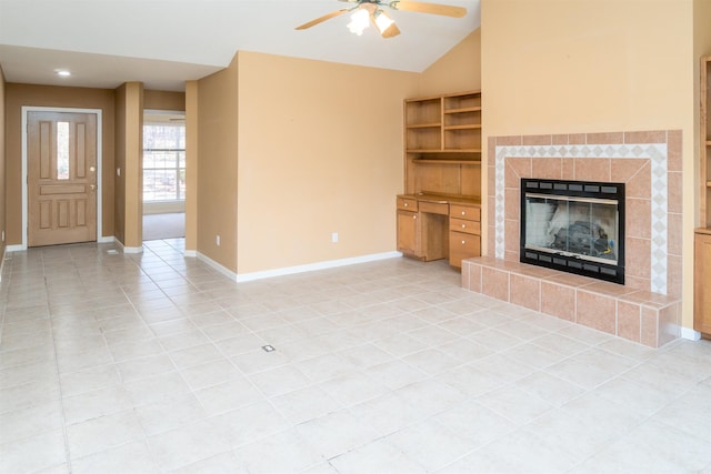 unfurnished living room with built in shelves, vaulted ceiling, ceiling fan, a tile fireplace, and light tile patterned floors