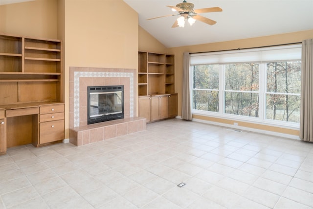 unfurnished living room with ceiling fan, a tiled fireplace, light tile patterned floors, and vaulted ceiling