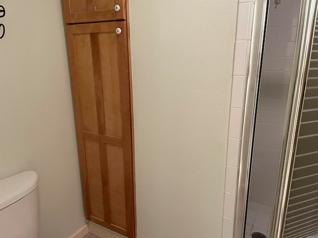 bathroom featuring an enclosed shower and toilet