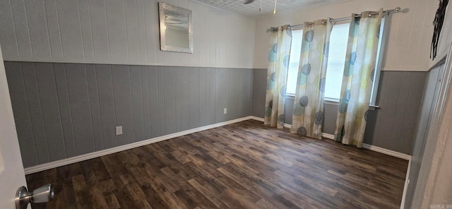 unfurnished room with dark wood-type flooring and ceiling fan