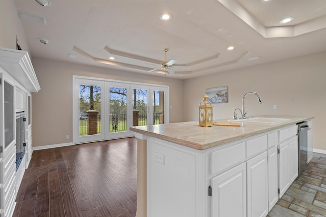 kitchen with white cabinetry, ceiling fan, a kitchen island with sink, and sink