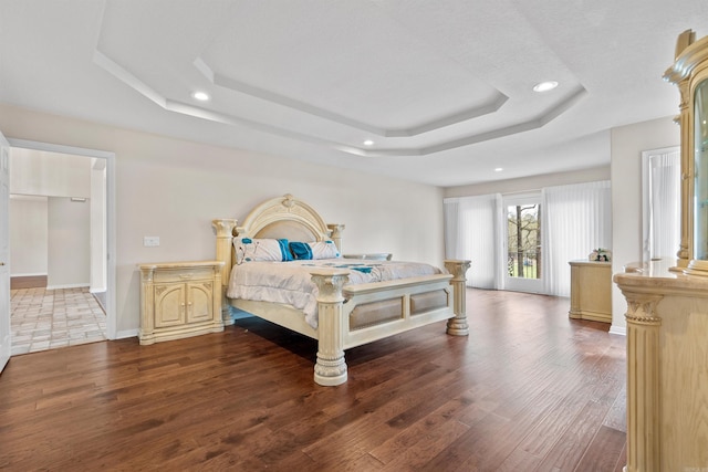 bedroom featuring a tray ceiling and hardwood / wood-style floors