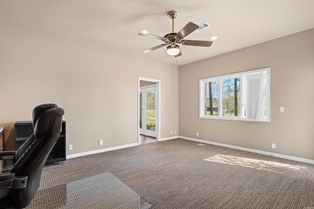 office space featuring dark carpet and ceiling fan