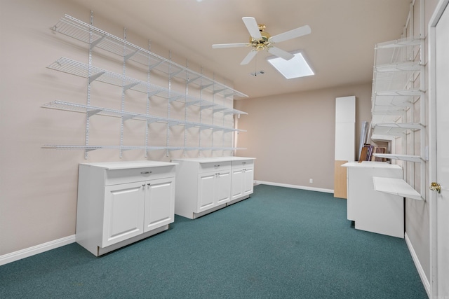 laundry room with ceiling fan, a skylight, and dark colored carpet