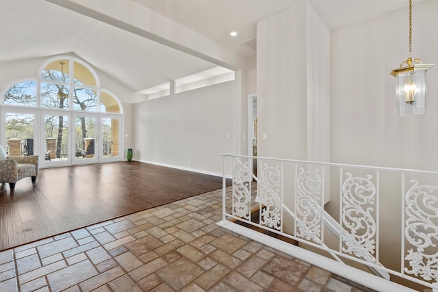 interior space with an inviting chandelier, lofted ceiling, and hardwood / wood-style floors