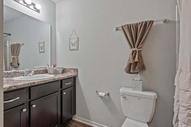 bathroom featuring a shower with shower curtain, vanity, and toilet