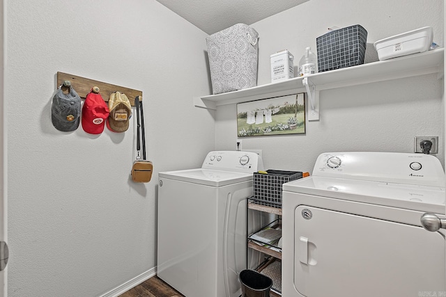 laundry room featuring a textured ceiling, washing machine and dryer, and dark hardwood / wood-style flooring