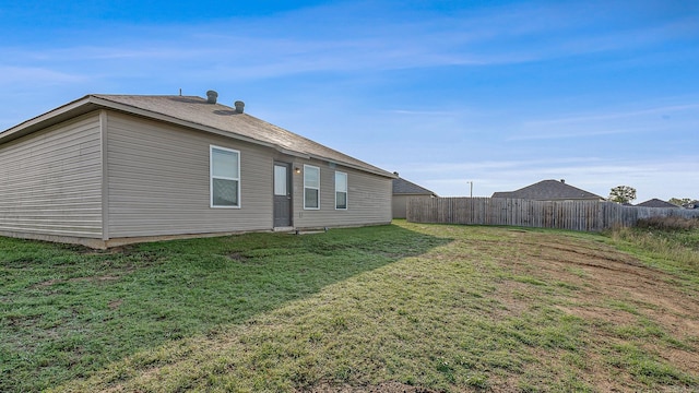 rear view of property featuring a lawn