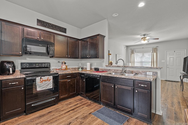 kitchen featuring ceiling fan, hardwood / wood-style flooring, sink, and black appliances